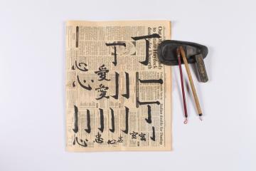 蘭大弼在報紙上練習中文（原作名稱：毛筆座、硯台、墨與習字報紙。典藏者：彰基文史博物館。發佈於《彰基文史博物館文史資料庫》