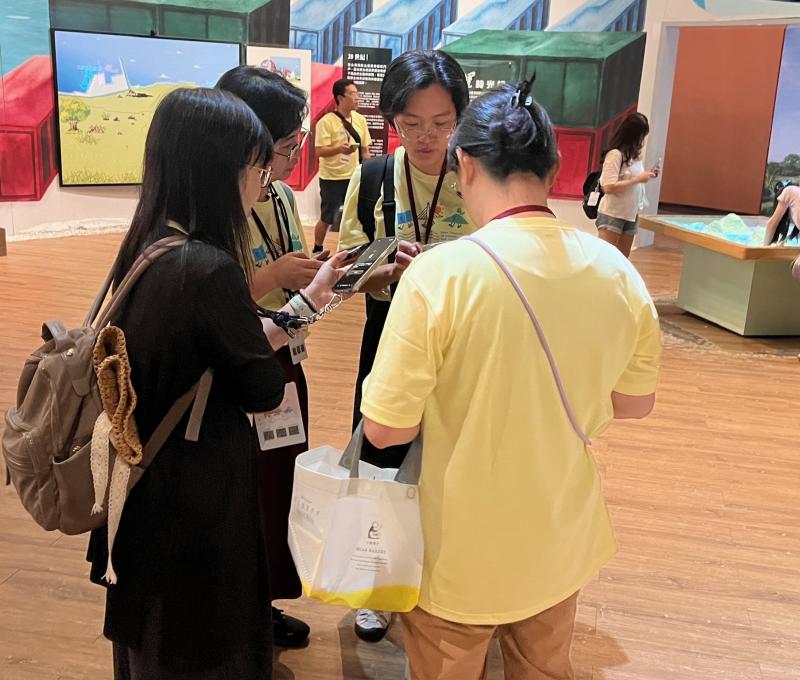 手機螢幕的微光映在臉上，學員分組討論、交叉比對答案。從 19 世紀航運到 20 世紀臺北港，時間軸上的每一格都是解謎關鍵。（照片提供者：林英斌 / 拍攝日期：2026.08.11）