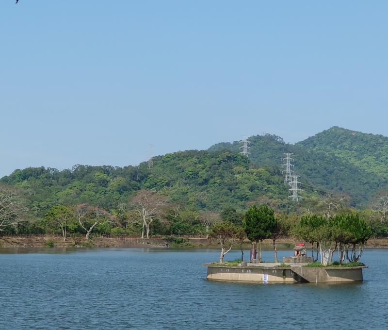   	水中土地公廟，遠處"草嶺山"為盾狀火山。照片拍攝者：洪光君 / 拍攝日期：2021/4/6