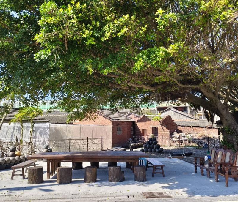 大樹公芳苑客廳-利用漂流木製作的大木桌和長板凳及圓椅（照片提供者：林雅婷 / 拍攝日期：2025.02.14）