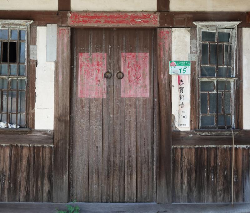 宅體正身立面為「凹壽」形式；外牆多為磚造，正門設木板雙開門，兩側開洋式上下推拉窗，窗扇分割細緻、保存良好，窗上並以突出磚線腳收邊，立面層次鮮明。／資料來源：毛毓翔拍攝（2025年4月23日）。