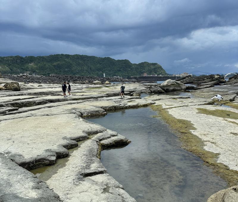 潮間帶岩盤與烏雲壓境的海岸景致。拍攝者：吳宸陞／拍攝日期：2025/09/30